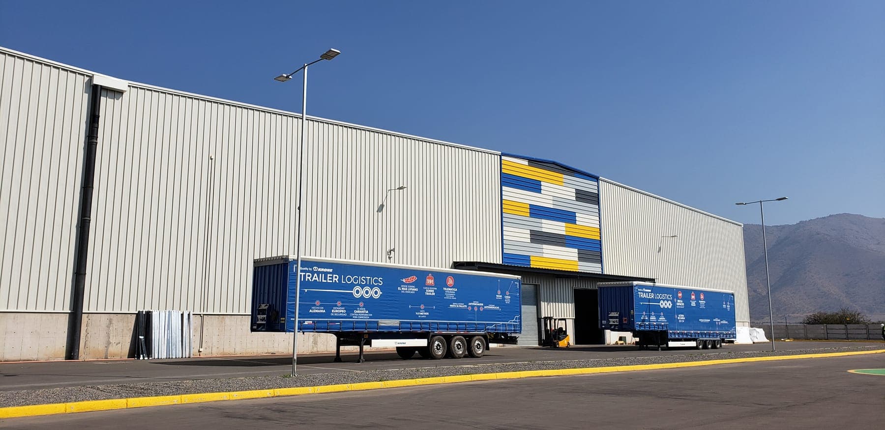 Facade of the Trailer Logistics distribution center in Lampa, with Krone trailers at the dock